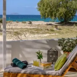 View of the sea from the patio of Paximadia Beachfront Apartment in Neo Kalamaki at sunset. The sky glows with warm colors, reflecting over the calm waters