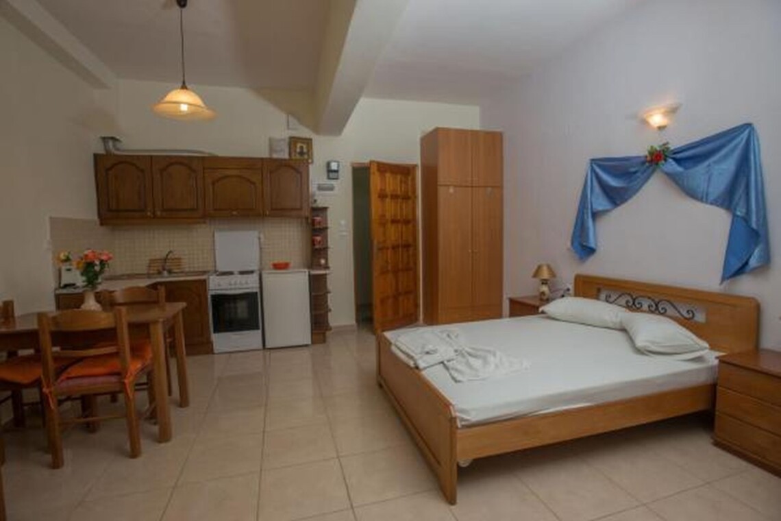 Bedroom with double bed and kitchnette at Sunset Holiday Apartment