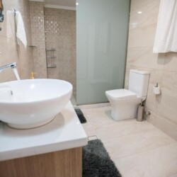 Contemporary bathroom with walk-in shower, stylish tilework, and modern amenities at Villa Virginia in Kalamaki.