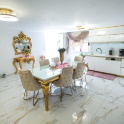 This stunning glass and gold dining table sets the tone for memorable meals and celebratory toasts.