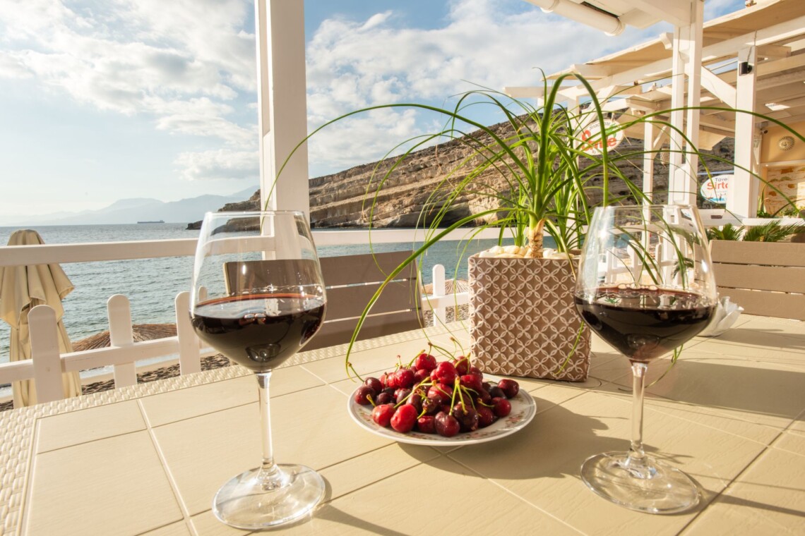 Sea view from private balcony in Matala with two glasses of red wine